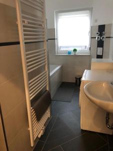 een badkamer met een wastafel, een toilet en een raam bij Gästewohnung 6 in Oschersleben