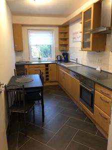 a kitchen with wooden cabinets and a table and a window at Gästewohnung 6 in Oschersleben