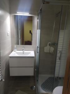 een badkamer met een witte wastafel en een douche bij Aldeia de Moura Morta 