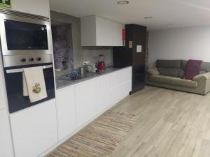 a kitchen with a counter and a couch in a room at Aldeia de Moura Morta in Moura Morta