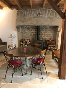 comedor con mesa, sillas y chimenea en Gîtes Le Fer A Cheval Vassivière, en Royère-de-Vassivière