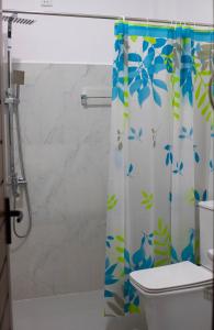 a bathroom with a shower curtain with blue birds on it at CRYSTAL RIVERSTON DECK in Matale