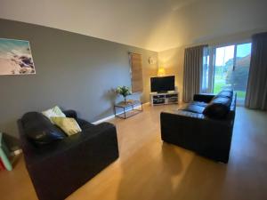 een woonkamer met 2 banken en een flatscreen-tv bij Middleton Bay Retreat in Albany