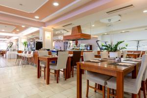 a restaurant with tables and chairs and a kitchen at Hotel Dražica - Hotel Resort Dražica in Krk