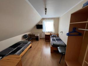 Kleines Zimmer mit 2 Betten und einem Schreibtisch. in der Unterkunft Atpūtas māja Sigulda in Sigulda