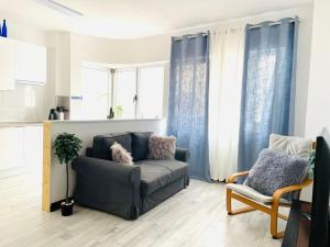 sala de estar con sofá y silla en LAS CANTERAS Sabor a Mar 2 Dormitorios "Parking Gratis", en Las Palmas de Gran Canaria