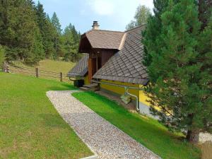 a small house with a brown roof in a field at Cozy holiday home in Prebl with a view in the Klippitzt rl ski area in Prebl