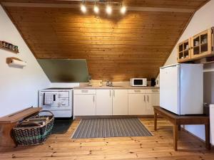 a kitchen with white appliances and a wooden ceiling at Cozy holiday home in Prebl with a view in the Klippitzt rl ski area in Prebl