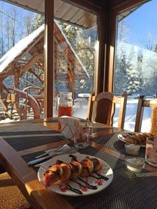 une table avec une assiette de nourriture au-dessus dans l'établissement Zatishok Bilya Richky, à Pilipets