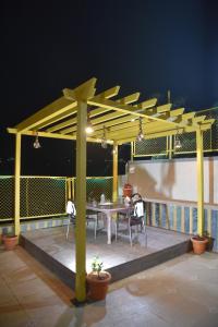 a pergola with a table and chairs on a patio at Rozaan Villa Valley View in Mahabaleshwar