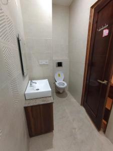 a bathroom with a white sink and a toilet at Hotel kartik in Zirakpur