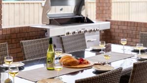 a table with a plate of food and a bottle of wine at The Callala Hideaway in Callala Beach