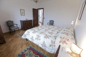 1 Schlafzimmer mit einem Bett, 2 Stühlen und einem Tisch in der Unterkunft Ca der Forn the Bread Oven House in Cascina Bricchetto Langhe - Italy in Trezzo Tinella