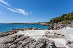 a stone walkway on the rocks near the water at Hotel Dražica - Hotel Resort Dražica in Krk
