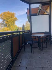 een wit scherm op een balkon met een tafel en stoelen bij Gästewohnung 5 in Oschersleben