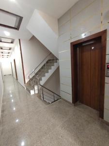 un corridoio vuoto con una scala in un edificio di Hotel kartik a Zirakpur
