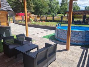 a patio with a table and chairs and a pool at Apartmán Žora in Dražov