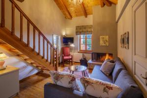 a living room with a couch and a fireplace at Agiannorema in Arachova