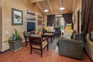 a living room with a couch and a tv at Aloe Guest House in Hermanus