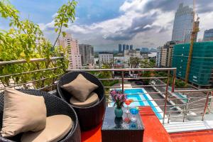 a balcony with chairs and a table with a view of a city at Roseland Sweet Hotel & Spa in Ho Chi Minh City