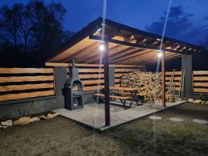 a patio with a grill and a picnic table at night at Apartmán Žora in Dražov
