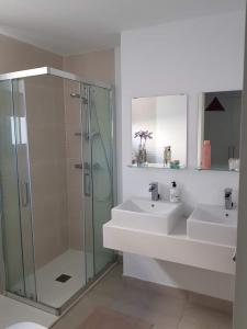 uma casa de banho com 2 lavatórios e uma cabina de duche em vidro. em Serenity Views 3 bedroom seaview em Estepona