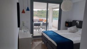um quarto com uma cama e uma varanda com uma mesa em Serenity Views 3 bedroom seaview em Estepona