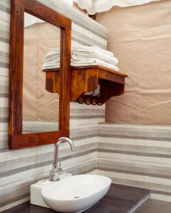 a bathroom with a sink and a mirror and towels at Real Desert Man Safari Camp in Jaisalmer