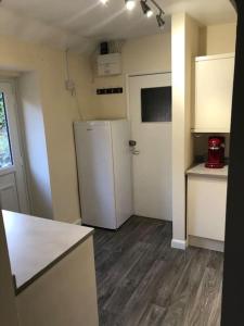 an empty kitchen with a refrigerator in a room at The Grooms Den @ Grove Farm in Fenny Compton