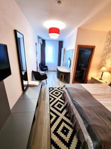 a bedroom with a bed and a tv and a desk at Motel Via Targu Mures in Cristeşti