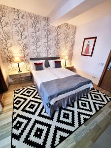 a bedroom with a bed and a black and white rug at Motel Via Targu Mures in Cristeşti