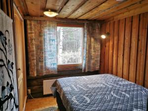 Un dormitorio con una cama en una habitación con ventana. en Soppela, en Syöte