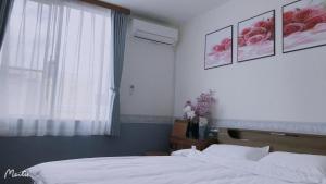 a bedroom with a bed and a window with roses on the wall at ホテルルネサンス土浦 in Tsuchiura +6 photos