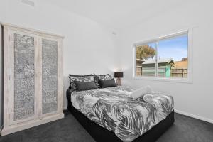 a bedroom with a bed and a window at All Beached Out - 8 guests, cental, 450m to beach! in Ocean Grove