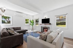 a living room with a couch and a fireplace at All Beached Out - 8 guests, cental, 450m to beach! in Ocean Grove