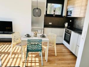 a kitchen with a table and chairs in a kitchen at Ferienwohnung EnsheimLiebe in Saarbrücken