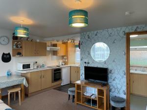 a kitchen with a television and a table with a counter at Idyllic Entire Chalet in Bideford Bay holiday Park near Clovelly in Bideford