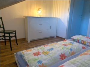 a bedroom with a bed and a dresser and a chair at Haus Eckert in Höchenschwand