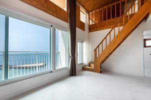 Zimmer mit einem großen Fenster und Meerblick in der Unterkunft Aewol Oceanstay in Jeju-do