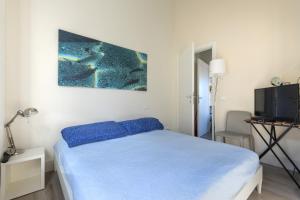 um quarto com uma cama azul e uma televisão em Il Quartiere apt Capraia em Pomonte