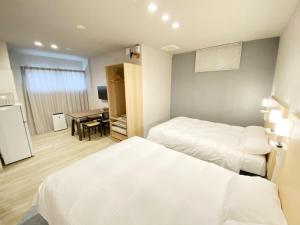 a hotel room with two beds and a table at Takanobashi HOTEL in Hiroshima