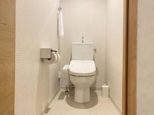 a bathroom with a white toilet in a stall at Takanobashi HOTEL in Hiroshima