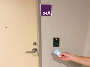 a person holding a wii remote in front of a door at Takanobashi HOTEL in Hiroshima +59 photos