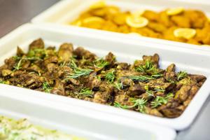 two white dishes of food with rosemary on top at Hotel Dražica - Hotel Resort Dražica in Krk