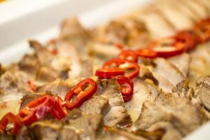 a plate of food with red peppers on it at Hotel Dražica - Hotel Resort Dražica in Krk
