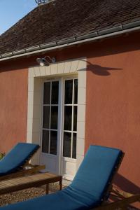duas cadeiras azuis sentadas fora de uma casa em Domaine de la Trigalière em Ambillou