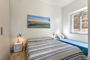 um quarto com uma cama e uma janela em Il Quartiere apt Giglio em Pomonte