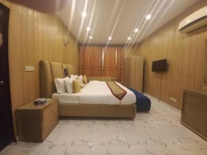 a hotel room with a bed and a tv at Hotel Premier Inn Johar Town Lahore in Lahore