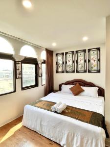 een slaapkamer met een groot bed in een kamer met ramen bij Longzhu Guesthouse in Bangkok