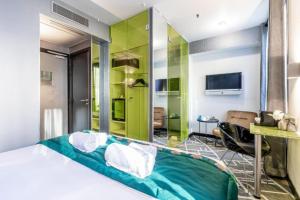 - une chambre avec un lit et un mur vert dans l'établissement Sublim by Sweet Inn, à Paris